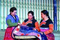 楼氏珠女士（左）向赫蒙族妇女分享服装刺绣经验