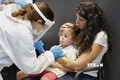 Nhân viên y tế lấy mẫu xét nghiệm COVID-19 cho trẻ em tại Tel Aviv, Israel ngày 19/8/2021. Ảnh: AFP/TTXVN