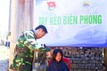Thượng tá Nguyễn Xuân Linh, Chính trị viên Đồn Biên phòng Cửa khẩu quốc tế La Lay cắt tóc cho trẻ em Lào. Ảnh: baoquangtri.vn