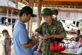 Nhân viên quân y, Bộ chỉ huy Quân sự tỉnh Nghệ An thăm khám, cấp phát thuốc cho nhân dân vùng lũ ở huyện Kỳ Sơn. Ảnh: Văn Tý-TTXVN