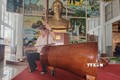 Nghệ nhân Võ Văn Bá sử dụng nhạc cụ đờn cò làm từ gốc dừa lớn nhất Việt Nam. Ảnh: Huỳnh Phúc Hậu - TTXVN