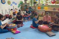 Các giáo viên và phụ huynh Trường Mầm non A Xing, huyện Hướng Hóa may tặng học sinh túi vải để thay thế túi ni lông đựng đồ. Ảnh: Thanh Thủy-TTXVN