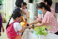 Giáo viên Trường Mầm non Tuổi thơ (Quận 8) hướng dẫn trẻ rửa tay trước khi vào lớp. Ảnh: Thu Hoài - TTXVN