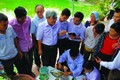 Tiến sĩ Bùi Quang Tề - chuyên gia về lĩnh vực nuôi trồng thủy sản hướng dẫn các học viên kiểm tra bệnh tích của cá. Ảnh: Trung Xuân