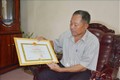 Cựu chiến binh Nguyễn Tấn Chính với giấy khen do UBND thành phố Buôn Ma Thuột tặng vì đã có thành tích xuất sắc trong phong trào thi đua yêu nước giai đoạn 2015 – 2020. Ảnh: Hoài Thu – TTXVN.