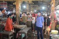 Cán bộ quản lý chợ Mai (phường Thọ Quang, quận Sơn Trà) tuyên truyền, nhắc nhở người dân chấp hành nghiêm chỉnh các biện pháp phòng, chống COVID-19. Ảnh: Văn Dũng - TTXVN