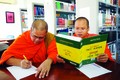 Các tăng sinh Khmer tra cứu từ vựng với Từ điển song ngữ Việt - Khmer trong thư viện của Trường Đại học Trà Vinh. Ảnh: An Hiếu