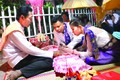 Thầy Achar Danh Khiêm thực hiện nghi thức buộc chỉ tay chúc phúc cô dâu, chú rể trong một lễ cưới truyền thống của đồng bào Khmer Nam Bộ ở tỉnh Sóc Trăng. Ảnh: Sơn Hên
