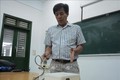Thầy Nguyễn Văn Thịnh thuyết minh về nguyên lý hoạt động của máy nghiền bi trục đứng. Ảnh: Văn Dũng – TTXVN
