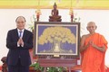 Chủ tịch nước Nguyễn Xuân Phúc tặng quà lưu niệm cho Học viện Phật giáo Nam tông Khmer. Ảnh: Thống Nhất – TTXVN