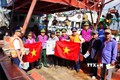 Lực lượng phối hợp tuyên truyền, trao cờ cho ngư dân. Ảnh: TTXVN phát