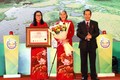 Lãnh đạo Sở Văn hóa, Thể thao và Du lịch Đồng Nai đón nhận bằng Kỷ lục châu Á với món xôi chiên phồng Đồng Nai.Ảnh: nhandan.vn