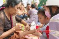 Trẻ em được những người lớn tuổi cột chỉ tay cầu an trong ngày lễ hội. Nguồn:baobinhphuoc.com.vn