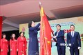 Phó Chủ tịch nước Đặng Thị Ngọc Thịnh gắn Huân chương Độc lập hạng Nhì lên lá cờ truyền thống của nhà trường. Ảnh: Thanh Tùng - TTXVN