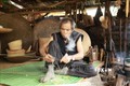 Nghệ nhân Đinh Bi (làng Kgiang, xã Kông Lòng Không, huyện Kbang, tỉnh Gia Lai) dù đã ở tuổi 65 nhưng đôi tay vẫn lanh lợi, đôi mắt sáng trau chuốt từng đường nan. Ảnh: Quang Thái- TTXVN