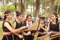 Các cô gái Bahnar đang chỉ dạy cách chơi đàn T'rưng cho các em học sinh. Ảnh: Quang Thái - TTXVN