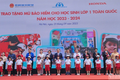 Đại diện Ban tổ chức trao tặng mũ bảo hiểm cho các em học sinh Trường tiểu học Phú Đô (Hà Nội). Ảnh: nhandan.vn
