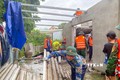 Bộ đội Biên phòng tỉnh Thừa Thiên - Huế phối hợp với chính quyền địa phương hỗ trợ các gia đình bị thiệt hại lợp lại, gia cố mái nhà. Ảnh: TTXVN phát