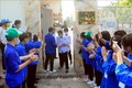 Sinh viên tình nguyện chào mừng thí sinh đầu tiên hoàn thành môn Ngoại ngữ tại điểm thi trường THPT Hồng Bàng, thành phố Hải Phòng. Ảnh: An Đăng - TTXVN