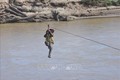 Người dân liều mình đu dây qua sông Pô Kô. Ảnh: Khoa Chương – TTXVN