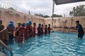 Các em học sinh của trường Tiểu học Ngô Thì Nhậm, xã Ia Chim, thành phố Kon Tum khởi động trước khi xuống nước tập bơi. Ảnh: TTXVN