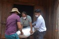 UBND xã Ea Kiết, huyện Cư M’Gar chở gạo cứu đói đến trao tận tay cho gia đình anh Bùi Quốc Thọ (giữa), hộ gặp khó khăn do dịch COVID-19. Ảnh: Hoài Thu - TTXVN