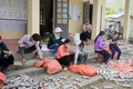 Thành viên Câu lạc bộ “Vệ sinh môi trường” và bà con bản Lun 1, xã Tà Mung, huyện Than Uyên (Lai Châu) làm gạch sinh thái xây dựng tường bao, cổng chào nhà văn hóa của bản. Ảnh: Việt Hoàng-TTXVN
