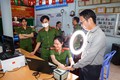 Cán bộ Công an phường Tân An, quận Ninh Kiều hướng dẫn người dân thực hiện đăng ký tài khoản định danh điện tử mức độ 2. Ảnh: TTXVN phát