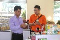 Ông Trần Duy Linh, Giám đốc Công ty TNHH Chế biến dừa sáp Cầu Kè (bên phải) giới thiệu sản phẩm “Dừa sáp sợi” đạt chuẩn OCOP 5 sao đến người tiêu dùng. Ảnh: Thanh Hòa - TTXVN