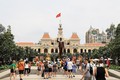 Đoàn khách quốc tế tham quan Tượng đài Chủ tịch Hồ Chí Minh trước Trụ sở HĐND, UBND Thành phố. Ảnh: Hồng Đạt - TTXVN
