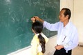 Ông Danh Nghe dạy học chữ Khmer cho con em đồng bào dân tộc. Ảnh: Lê Huy Hải - TTXVN