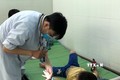 Bác sĩ kiểm tra sức khỏe cho trẻ mắc tay chân miệng tại Khoa Bệnh Nhiệt đới, Bệnh viện Sản Nhi Quảng Ngãi, tỉnh Quảng Ngãi. Ảnh: Đinh Hương - TTXVN