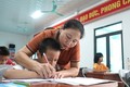 Cô giáo Hoàng Thị Vỵ dạy chữ cho trẻ bị khuyết tật. Ảnh: Việt Dũng - TTXVN