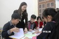 Cô giáo Nguyễn Thị Mai hướng dẫn học sinh làm bài tập thực hành. Ảnh: Phan Quân - TTXVN