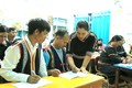 Cô giáo Kso H'Vớt đang chăm chú uốn nắn từng nét chữ cho các học viên. Ảnh: Quang Thái- TTXVN