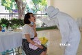 Nhân viên y tế quận Ba Đình thực hiện lấy mẫu xét nghiệm dịch hầu họng cho người dân từ Đà Nẵng trở về. Ảnh: Mạnh Khánh-TTXVN