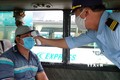 Lực lượng chức năng bến xe phía Bắc thành phố Nha Trang kiểm tra thân nhiệt hành khách khi lên xe. Ảnh: Nguyễn Dũng – TTXVN