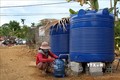 Người dân xã Mai Hóa huyện Tuyên Hóa, tỉnh Quảng Bình phấn khởi khi được sử dụng nước miễn phí tại một điểm cấp nước. Ảnh: Văn Tý-TTXVN
