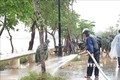 Các lực lượng dọn dẹp bùn đất tại khu vực 2 bên bờ sông Hương. Ảnh: Tường Vi - TTXVN