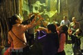 Các du khách đón những giọt nước từ nhũ đá trong động Hương Tích để cầu mong một năm mới nhiều sức khỏe, an lành và hạnh phúc. Ảnh: Minh Đức - TTXVN
