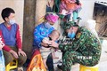 Trung tá Nguyễn Đức Tám khám bệnh cho dân bản. Ảnh: Hồng Ninh - TTXVN