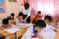 Giáo viên Trường Tiểu học Đoàn Kết, huyện Phong Thổ (Lai Châu) hướng dẫn học sinh viết chữ. Ảnh: Việt Hoàng-TTXVN
