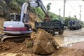 Phương tiện, cơ giới giải tỏa đất đá đổ xuống mặt đường  ở tỉnh Bình Định. Ảnh: Tường Quân - TTXVN
