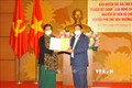 Nguyên Phó Chủ tịch thường trực Quốc hội Tòng Thị Phóng tiếp nhận Giấy chứng nhận đăng ký bản quyền tác giả. Ảnh: Minh Đức - TTXVN
