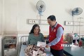 Trao kinh phí của Trung ương Hội Chữ thập đỏ Việt Nam hỗ trợ gia đình có người bị thương trong vụ tai nạn. Ảnh: TTXVN

