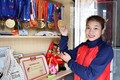 Vận động viên Triệu Thị Phương Thủy bên tủ huy chương các loại mà cô đã giành được. Ảnh: Trung Kiên - TTXVN