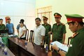 Cơ quan Công an thực hiện lệnh khởi tố bị can và bắt tạm giam đối với Nguyễn Hữu Hóa (áo trắng, bên phải). Ảnh: TTXVN phát