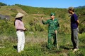 Bộ đội Biên phòng tỉnh Kon Tum hướng dẫn đồng bào dân tộc chữa bệnh khô lá trên cây cà phê mới trồng. Ảnh: Khoa Chương