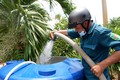 Thanh niên và dân quân là lực lượng túc trực thường xuyên hỗ trợ cấp nước cho người dân vùng hạ huyện Cần Giuộc, tỉnh Long An. Ảnh: Đức Hạnh - TTXVN