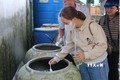 Cộng tác viên y tế cơ sở Sóc Trăng thả cá bảy màu trong chiến dịch diệt loăng quăng phòng chống sốt xuất huyết. Ảnh: Tuấn Phi-TTXVN